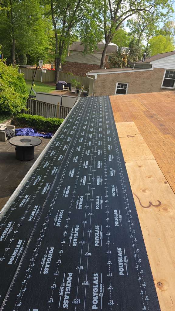 Roofer installing shingles